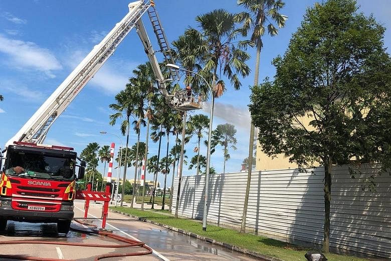Above: Singapore Civil Defence Force (SCDF) officers using water jets to contain the fire. Far left and left: SCDF deployed 13 emergency vehicles and about 55 firefighters. At the height of the operation, eight water jets, foam and an unmanned firefi