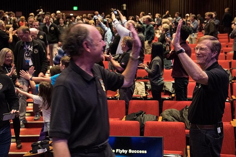 New Horizons project scientist Hal Weaver (right) of the Johns Hopkins Applied Physics Laboratory is seen in a Nasa photo high-fiving a team member on New Year's Day after receiving confirmation that New Horizons has completed a fly-by of Ultima Thul