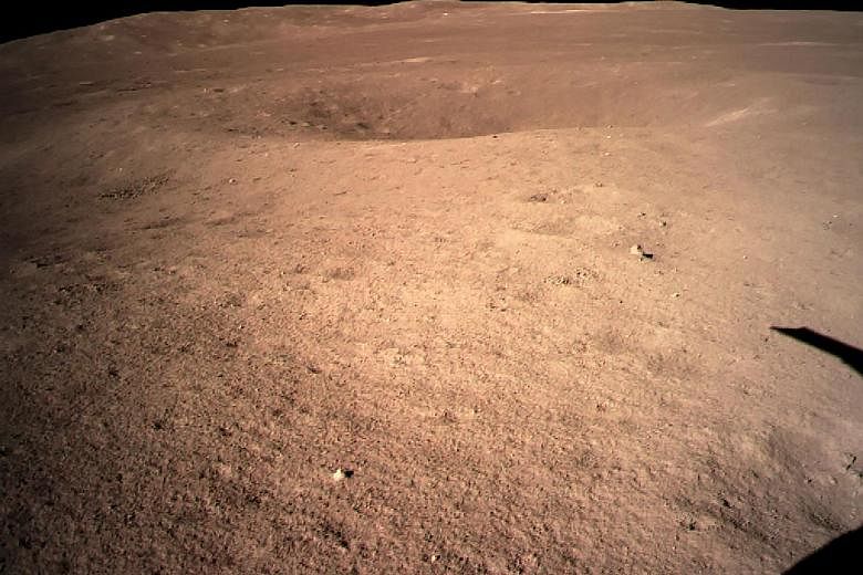 Above: An image of the far side of the Moon taken by the Chang'e-4 probe. Left: Researchers at the Beijing Aerospace Flight Control Centre celebrating the landing yesterday.