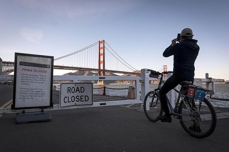 A cyclist snapping a photo outside the closed entrance to Fort Point in the Golden Gate National Recreation Area in San Francisco, California, on Wednesday.