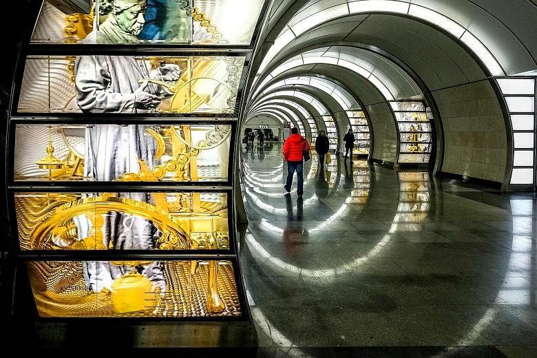 Cylindrical white light boxes (above) double as seats at the Solntsevo metro station; while artworks (left) dot the walls of the Fonvizinskaya station.