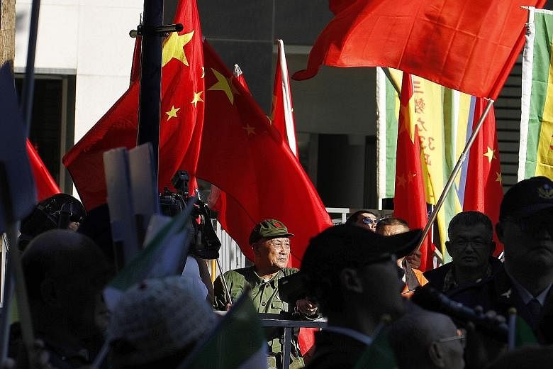A pro-China demonstrator waving Chinese flags outside the venue of the Taipei-Shanghai Twin City Forum held in Taipei recently. Beijing has always regarded Taiwan as a breakaway province with no option but to return to the motherland.