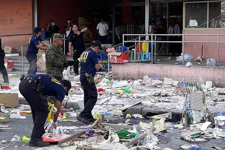 Police gathering evidence outside a shopping mall in Cotabato city, southern Philippines, where an explosion took place on New Year's Eve. A Philippine military official says the attack was probably in retaliation for the deaths of four militants in 