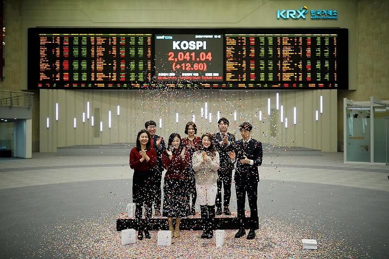 Korea Exchange staff at a closing event of the 2018 stock market in Seoul on Dec 28. The end of 2018 saw global markets roiled by volatility, caused by rising interest rates and US-China trade tensions, among other things.
