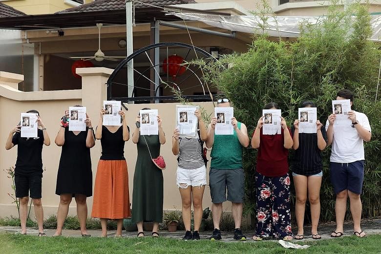 Above: A woman believed to be the owner of Platinium Dogs Club seen leaving the house at 7 Galistan Avenue, where the pet boarding service is based. Right: A group of people outside Platinium Dogs Club, holding up posters of the missing dog.