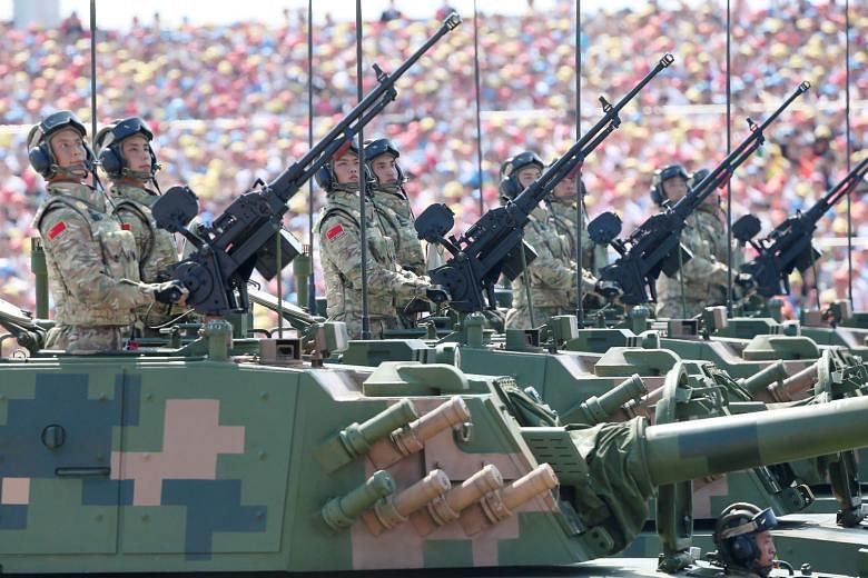 Chinese soldiers on armoured assault vehicles during a military parade in Beijing. President Xi Jinping has once again said that China reserves the right to use force to achieve reunification with Taiwan, even as it strives to achieve this goal via p