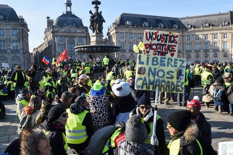 French "yellow vest" protesters with a sign reading "Injustice dictatorship stop. Free our comrades", as they rallied in Bordeaux yesterday. Over the past six weeks, the "yellow vest" demonstrators - named after the high-visibility jackets they wear 