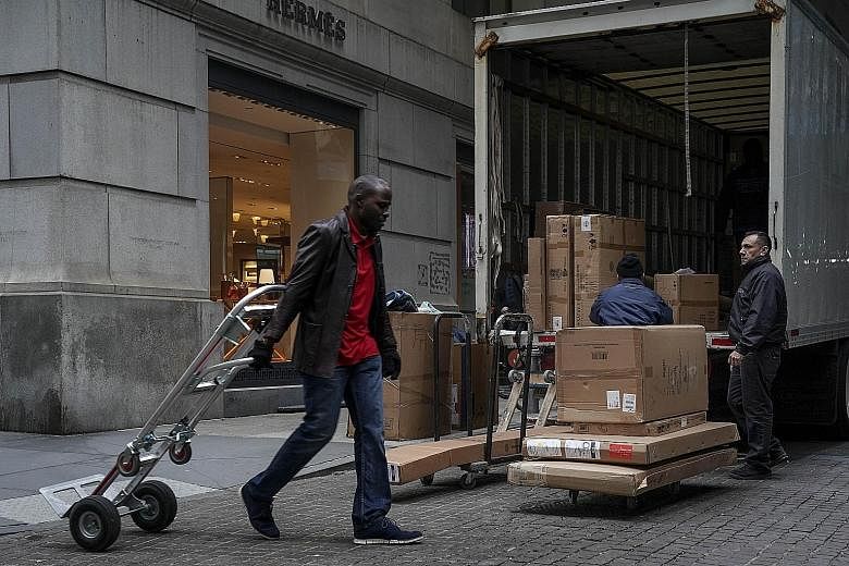 Workers unloading a truck in New York City. The US economy added 312,000 jobs last month, suggesting continued strength in the economy. The attention this week will be on whether talks in Beijing lead to progress in US-China trade relations.