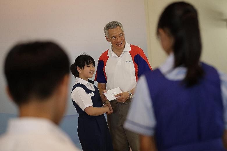 Townsville Primary School pupil Chloe Wee Xin Lei receiving her awards from Prime Minister Lee Hsien Loong yesterday.