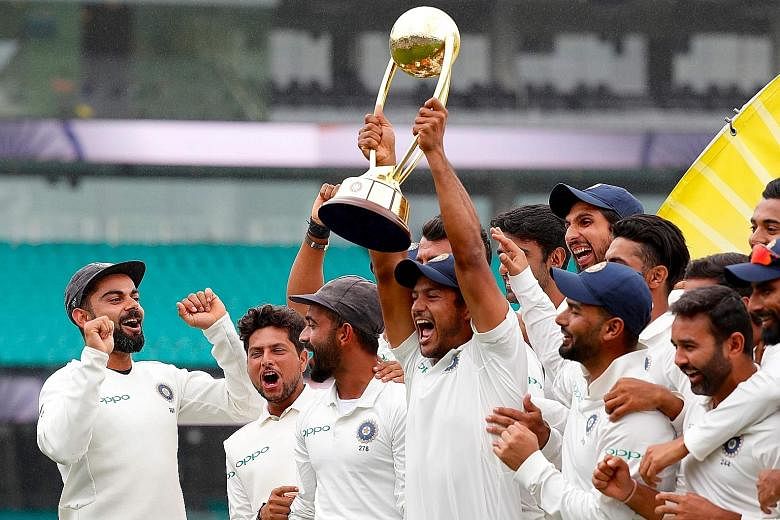 A jubilant India captain Virat Kohli cheering as his team celebrate with the Border-Gavaskar Trophy after they secured India's first Test series triumph on Australian soil.