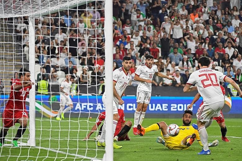 Top: The Yemen defence is all at sea as Iran forward Sardar Azmoun scored the fourth goal in their 5-0 win at the Mohammed Bin Zayed stadium in Abu Dhabi on Monday. Above: Iraq defender Ali Adnan celebrating his late free-kick goal which turned out t