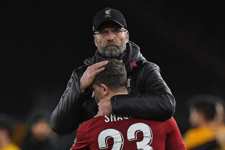 Liverpool manager Jurgen Klopp consoling Swiss midfielder Xherdan Shaqiri following the Reds' 2-1 FA Cup third-round loss to Wolves on Monday. The German made nine changes to the side who lost for the first time in the Premier League this season to M
