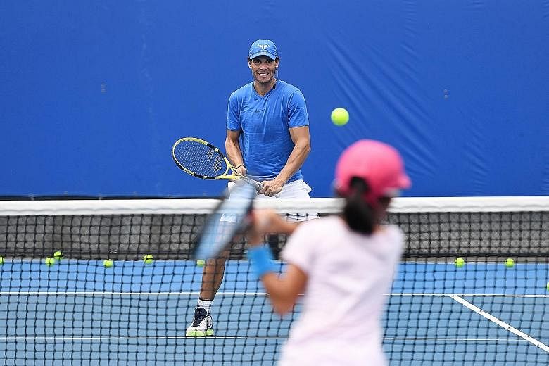 Rafael Nadal of Spain hitting with a young player from his academy in Brisbane last Saturday before his withdrawal. But he did not feel pain during a Sydney exhibition match yesterday.