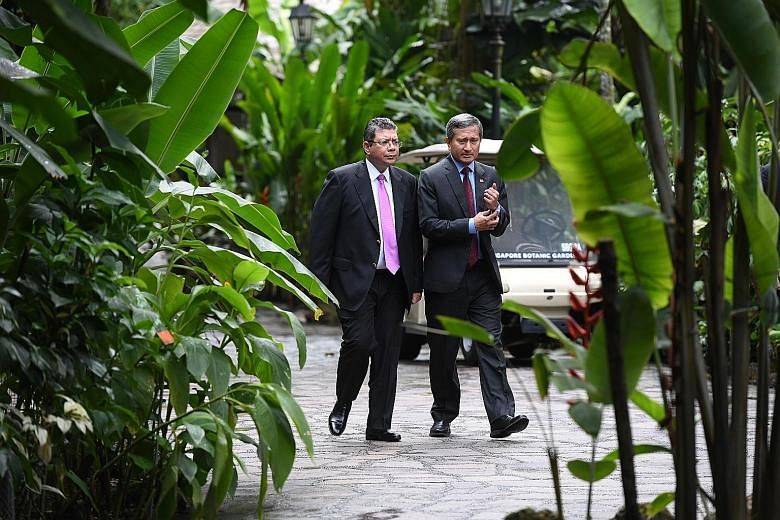 Left: Foreign Minister Vivian Balakrishnan and Malaysian Foreign Minister Saifuddin Abdullah arriving at The Villa in the Singapore Botanic Gardens' Ginger Garden, where they had lunch (above) yesterday. The meeting shows there is political will on b