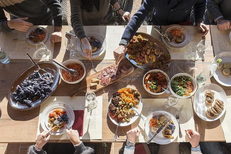 At Italian designer Brunello Cucinelli's headquarters in Solomeo, Italy, employees tuck into a multi-course lunch (above) for a nominal fee. LinkedIn, which does not charge for food even in its cafeterias, also provides several halal-meat options to 