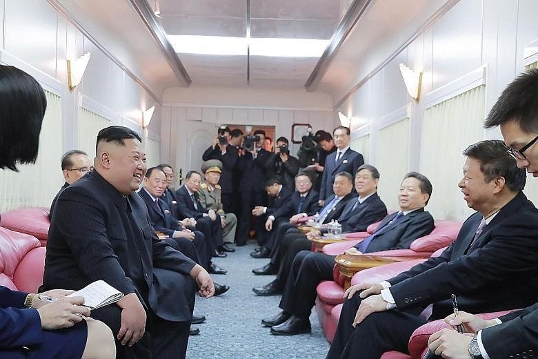 North Korean leader Kim Jong Un chatting with China's International Liaison Department head Song Tao on a train in Beijing on Wednesday, in a photo released by Pyongyang's Korean Central News Agency.