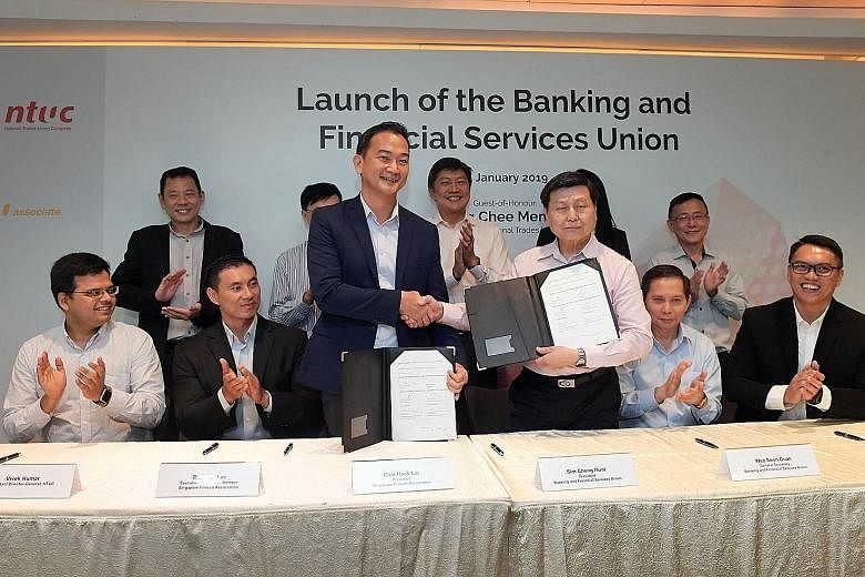 Singapore FinTech Association president Chia Hock Lai (centre left) and Banking and Financial Services Union president Sim Cheng Huat after signing a memorandum of understanding between the two organisations yesterday.