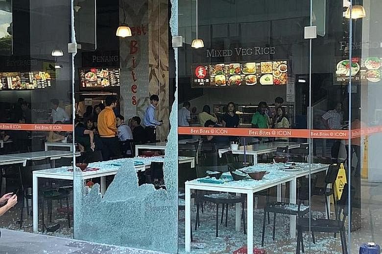 The shattered glass panel at the foodcourt of Icon@IBP. One person was taken to hospital and was discharged on the same day, while the other five suffered minor injuries.