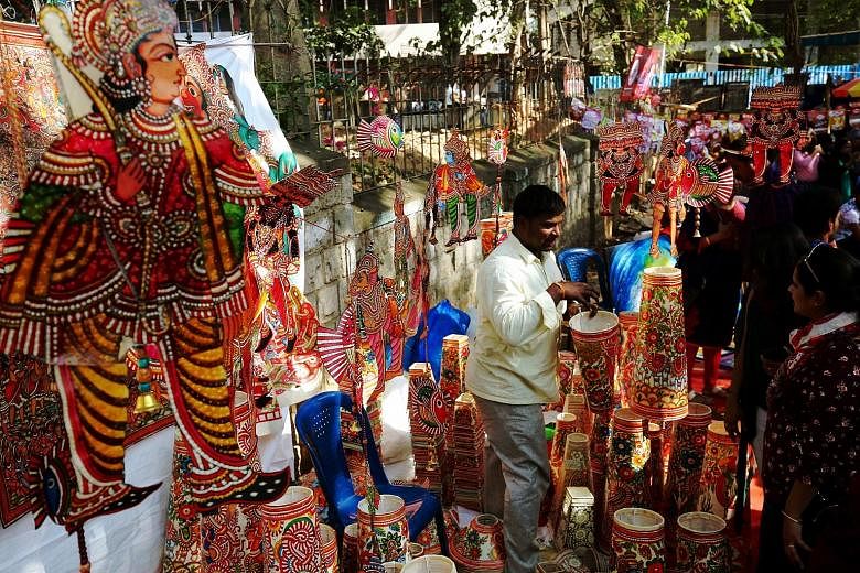 A roadside art fair in Bangalore. India is close to 50 per cent urban but considers itself a nation of villages, say the writers. They add that this seriously affects the country's growth prospects, leading to inefficiencies and loss of productivity 
