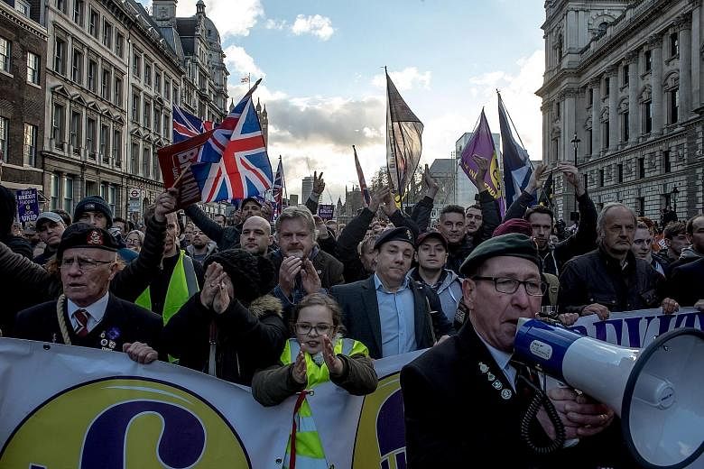 Demonstrators at a pro-Brexit rally in London last month. British Premier Theresa May is trying hard to make a chaotic no-deal Brexit seem as if it is an inescapable force of nature, says the writer. Yet it seems unlikely she would embrace the chaos 