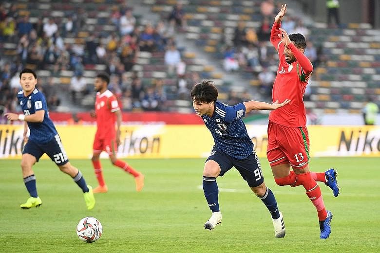 Japan's forward Takumi Minamino evading the attentions of Oman's Khalid Al-Braiki during their Group F game at the Hazza bin Zayed Stadium in Abu Dhabi. Japan won 1-0.