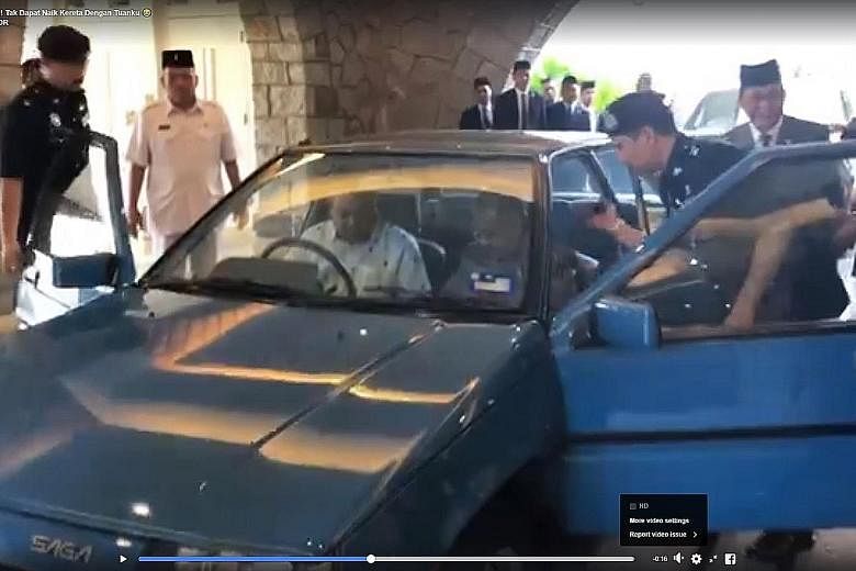 The video clip shows Johor Menteri Besar Osman Sapian trying to get into the Proton Saga as an officer helps Prime Minister Mahathir Mohamad with his seat belt.