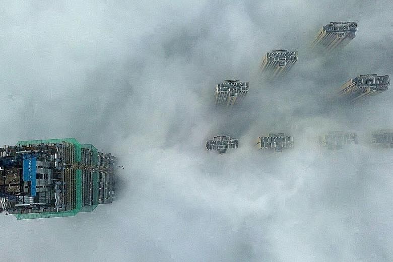 This aerial view shows the tops of high-rise buildings poking out from heavy fog in Yangzhou, in China's eastern Jiangsu province. The authorities in the city issued a red alert - the highest level - for heavy fog yesterday, with visibility reduced t