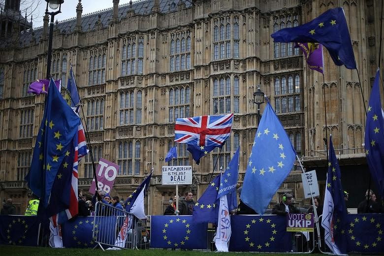 Pro-Brexit and anti-Brexit demonstrators outside the Houses of Parliament yesterday ahead of a parliamentary vote on the Brexit deal struck between British Prime Minister Theresa May's government and the EU. A comparatively narrow defeat could allow 