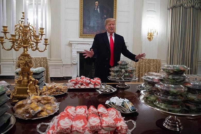 US President Donald Trump speaking in front of a spread of fast food he ordered for a ceremony honouring the Clemson Tigers football team in the State Dining Room of the White House on Monday. With the US government shutdown, about 800,000 federal em