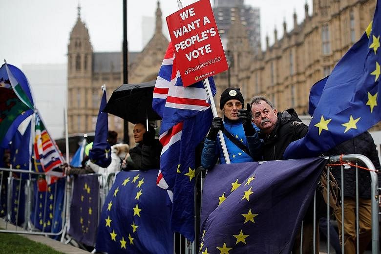 Anti-Brexit activists outside Parliament in London yesterday, after lawmakers voted 432 to 202 against British Prime Minister Theresa May's Brexit deal, the country's worst parliamentary defeat in modern history.