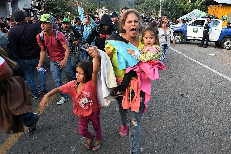 Honduran migrants marching on after breaking through a police cordon in Agua Caliente. Nearly 150 were turned away because they lacked documents.