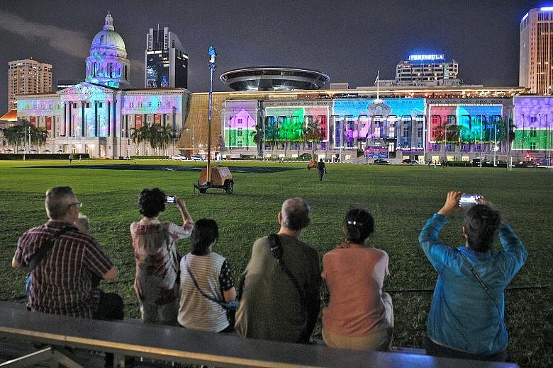 Viewers (above) enjoying a light show projected on the facade of the National Gallery Singapore at a media preview last night of the Light to Night Festival, which returns for a bumper edition until Feb 24. The Odyssey, commissioned by Art Skins on M