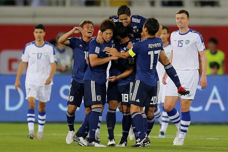 Japan celebrating Tsukasa Shiotani's strike from outside the box that gave the Samurai Blue a 2-1 comeback victory over Uzbekistan in their Asian Cup Group F match in Al Ain yesterday. Eldor Shomurodov's solo effort on 40 minutes, his fourth goal of 