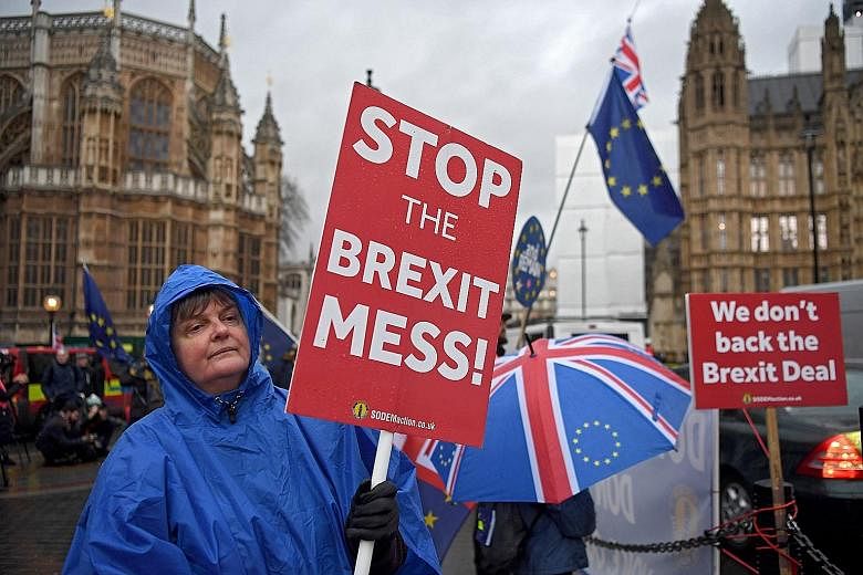Protesters outside the Houses of Parliament in London on Wednesday, after Mrs May's Brexit deal was crushed by Parliament in the biggest defeat for a British leader in modern political history. British Prime Minister Theresa May listening as Environm