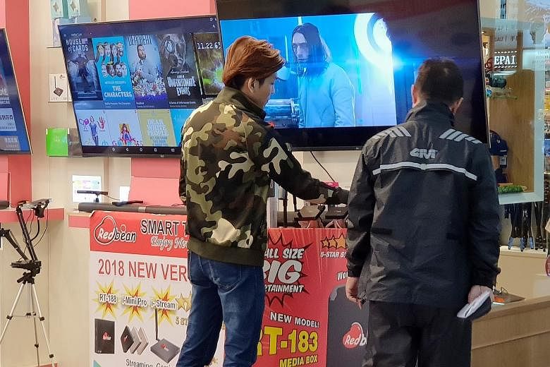 Streaming set-top boxes, which help consumers access pirated content, are openly promoted and sold at shops at Sim Lim Square. New laws to be tabled this year will ban the sale of such boxes.
