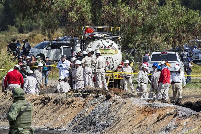 Forensic specialists at the site of the explosion in the central Mexican state of Hidalgo which killed more than 70 people who had rushed to collect petrol from a punctured pipeline last Friday.