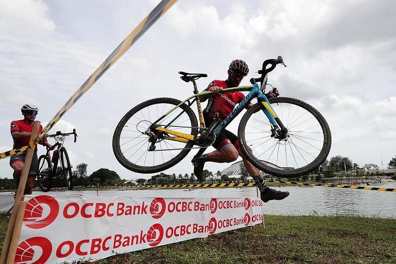 Bastian Dohling of Germany carrying his bike and jumping over one of the six obstacles in the race, en route to winning the Men's Elite category in the OCBC Cycle National Cyclocross Championship yesterday.