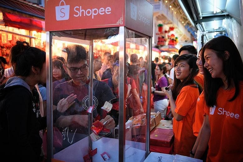 Visitors taking part in a lucky draw at the Shopee booth at the Chinese New Year festive street bazaar in Chinatown yesterday. They can learn first-hand how to shop on the app as well as purchase New Year goodies via the app.