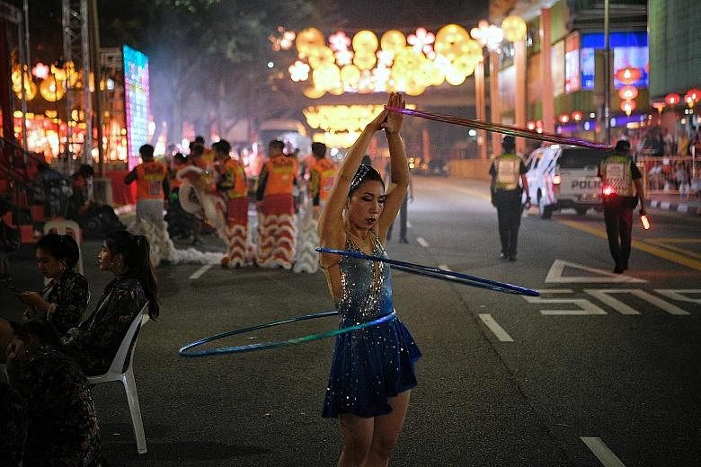 Members of the Song and Dance Theatre of Guangxi (above) captivating the crowds with their choreography and bright red costumes at the official opening ceremony and street light-up that kicked off this year's Chinatown Chinese New Year Celebrations o