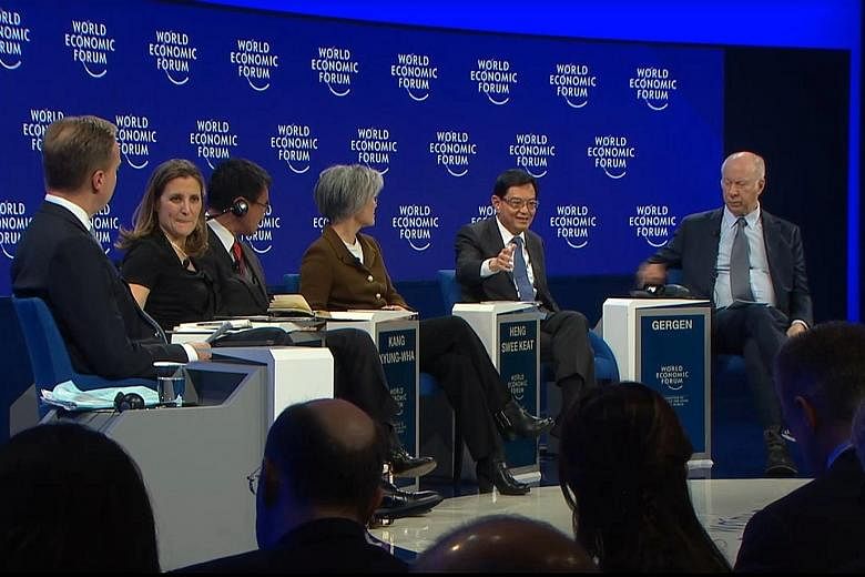 Finance Minister Heng Swee Keat speaking at the panel discussion at the World Economic Forum in Davos yesterday. With him were (from left) panel moderator and WEF president Borge Brende, Canada's Foreign Minister Chrystia Freeland, Japan's Foreign Mi