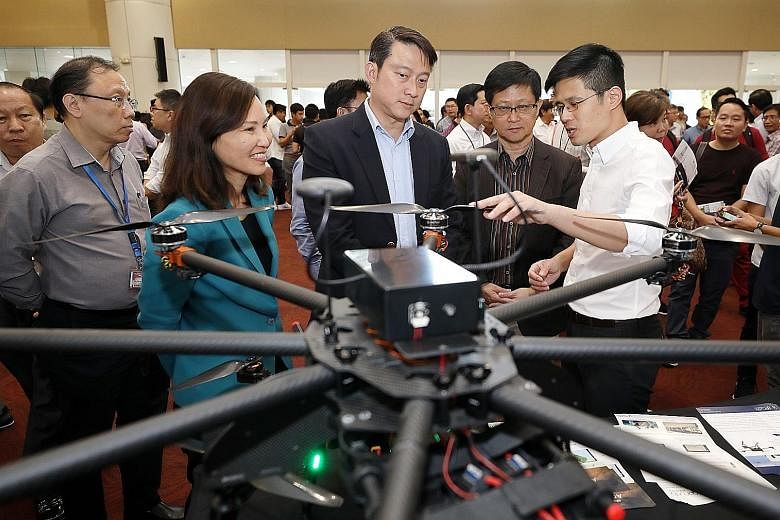 Garuda Robotics chief executive Mark Yong briefing Senior Minister of State for Transport and Health Lam Pin Min (centre), ITE CEO, Ms Low Khah Gek, and Science Centre Singapore CEO, Associate Professor Lim Tit Meng, at the inaugural Drone Technology