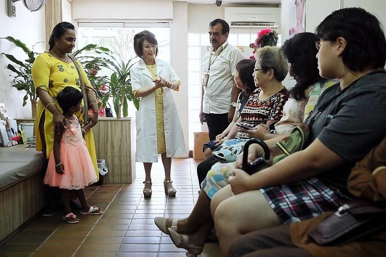 Dr Lily Neo speaking to software engineer Manju Somanathan (far left) and her daughter Keerti Arivazhagan, and other patients in her clinic.