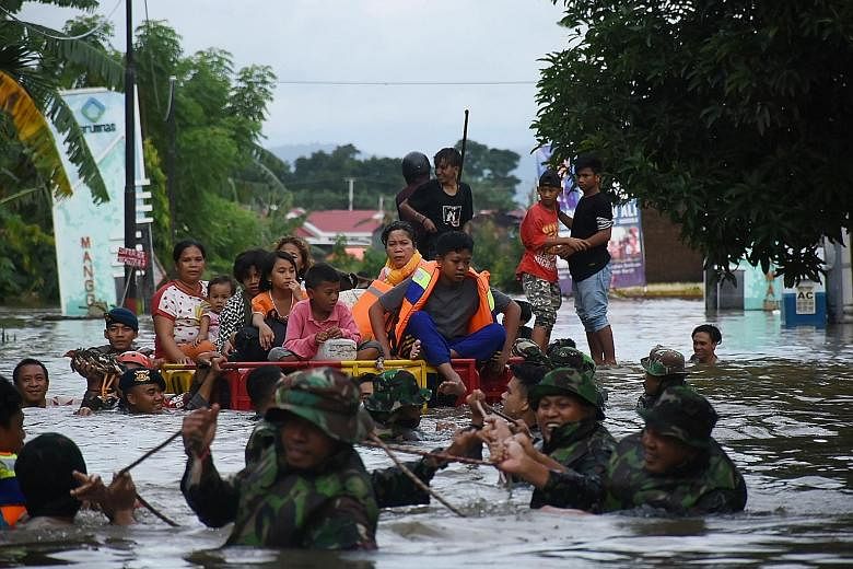Indonesian soldiers evacuating residents in Makassar on Wednesday. More than 3,000 people have been evacuated and at least 46 are being treated at local hospitals and health clinics, as heavy rain and strong winds pounded the southern part of Sulawes