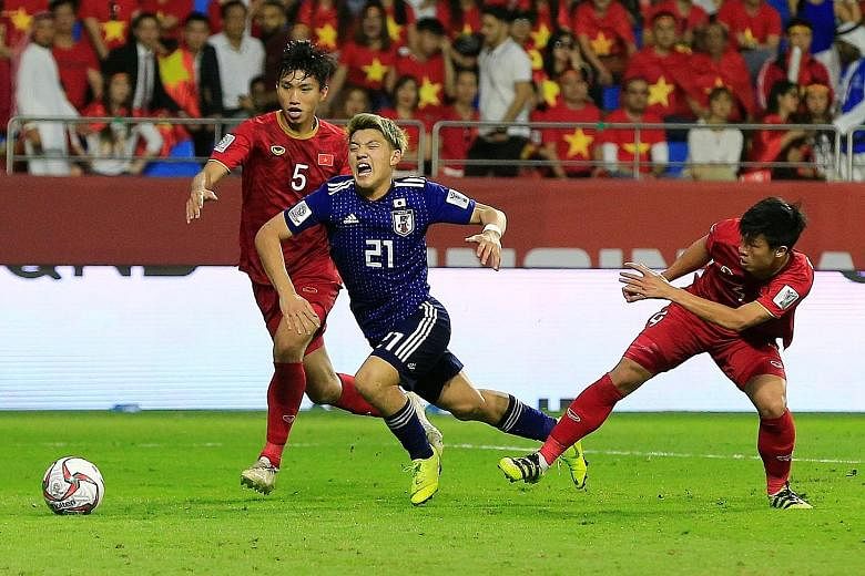 Japan's Ritsu Doan is fouled by Vietnam's Bui Tien Dung, resulting in a penalty being awarded after a VAR review. Doan converted the spot kick to send his team into the semi-finals.