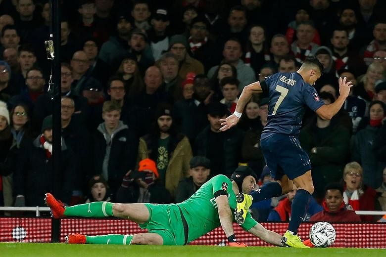 Manchester United forward Alexis Sanchez takes the ball around Arsenal goalkeeper Petr Cech before scoring the opening goal in the 3-1 FA Cup fourth-round victory at the Emirates Stadium on Friday.