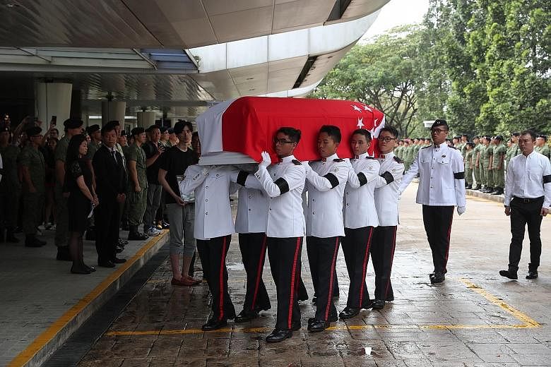 Actress Jayley Woo, Mr Pang's girlfriend, placing her hand on veteran actor Chen Shucheng's shoulder as they walk behind the hearse with other friends and relatives. Pall bearers from the Singapore Armed Forces carrying the casket of Corporal First C