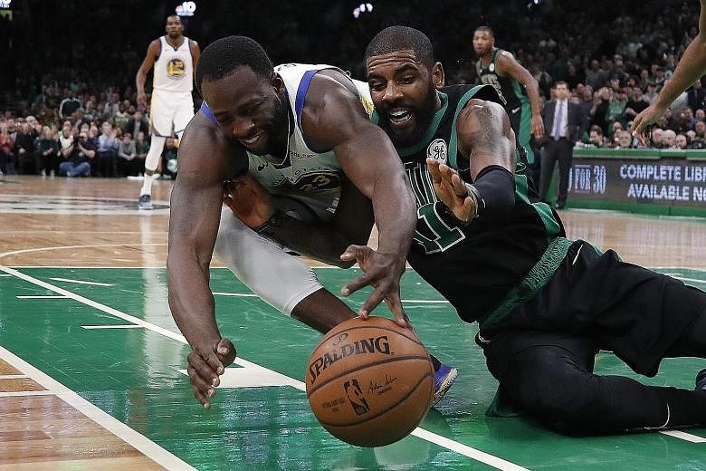 Golden State Warriors forward Draymond Green (left) and Boston Celtics guard Kyrie Irving battle for a loose ball at the TD Garden.