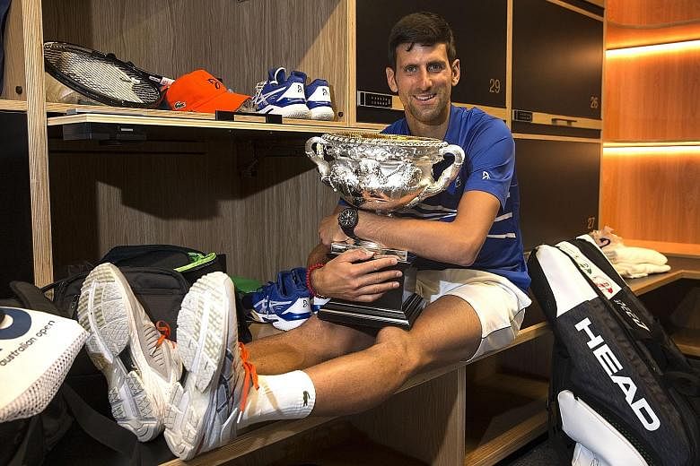 World No. 1 Novak Djokovic posing with the Norman Brookes Challenge Cup in the men's locker room after defeating Rafael Nadal in the men's singles final at the Australian Open in Melbourne yesterday.