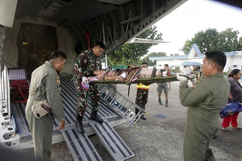 Philippine Air Force personnel transferring a victim of the twin bombing, at Edwin Andrews Air Base on Sunday.
