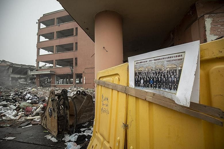A photograph of entrepreneurs, including the owner of a local shoe manufacturer, with then Chinese President Hu Jintao during a visit to Spain sits at an industrial complex undergoing demolition along Xiedu Avenue, which translates to "Shoe Capital" 